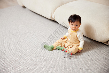 小宝宝坐在地毯上玩耍图片