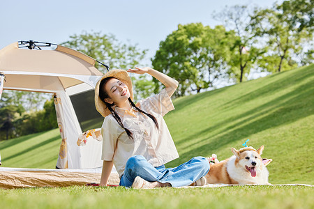 开心的小狗公园里露营享受太阳的美女和爱宠背景
