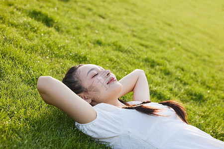 少女文艺躺在草地上闭眼晒太阳的白裙少女背景