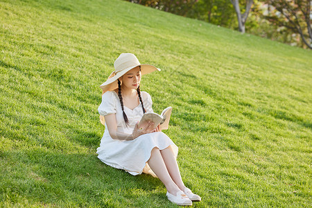 草坪上看书的文艺女性高清图片