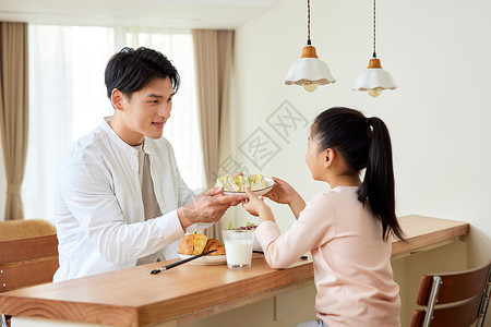 父女一起开心吃早餐高清图片