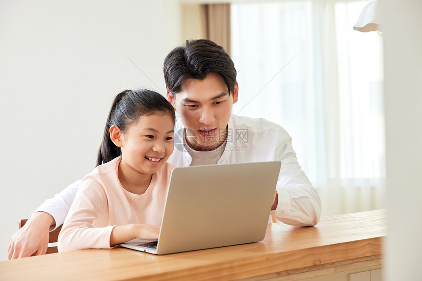 居家电脑学习的父女图片