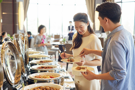 自助餐厅挑选菜品的夫妻高清图片