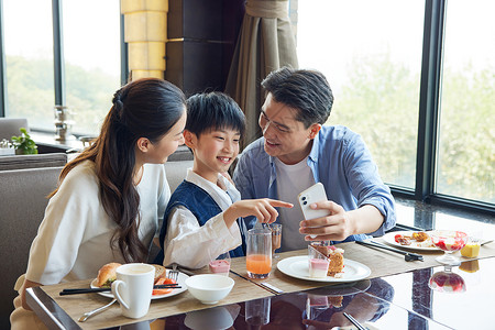 母亲节手机海报餐厅桌上看手机的一家人背景
