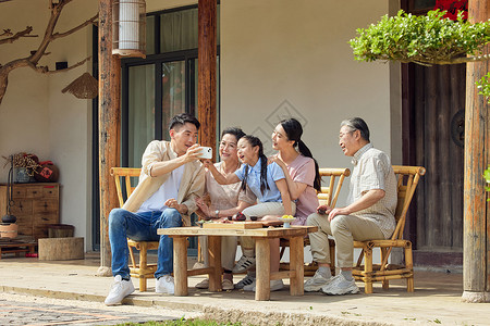 一家人坐在院子里聊天拍照背景图片