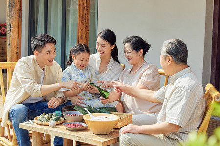 端午聚惠毛笔字一家人聚在一起包粽子背景