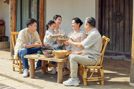 端午聚惠毛笔字端午一家人聚在一起包粽子背景