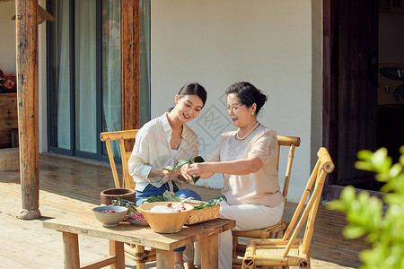 两个粽子婆媳二人在院子里包粽子背景