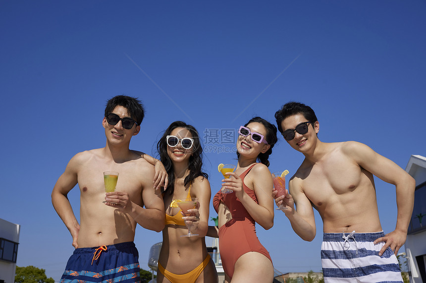 青年人夏日泳池聚会喝酒碰杯图片