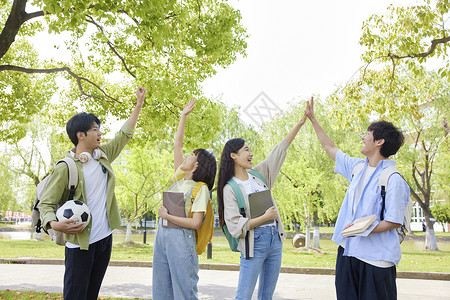 大学生们校园里击掌庆祝背景图片