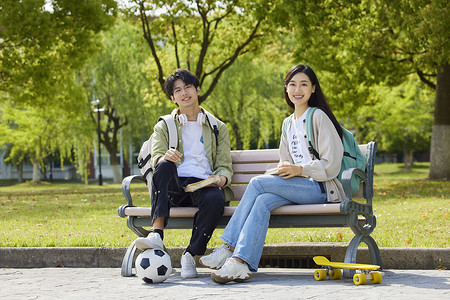 坐在长椅上的青春大学生形象背景图片