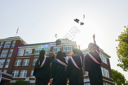 大学毕业生学士帽扔向空中背影图片