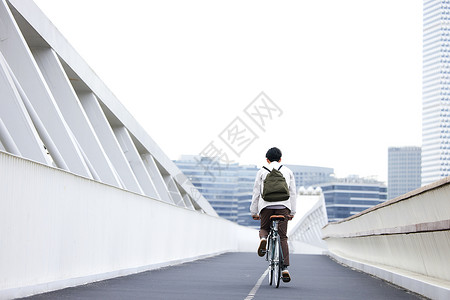 骑自行车出行男青年上班自行车通勤背影背景