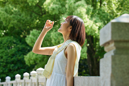 户外公园女性手拿花朵高清图片