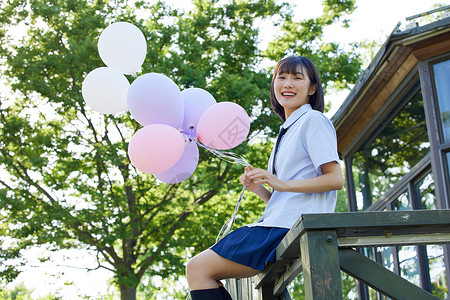 手拿气球的可爱女学生高清图片