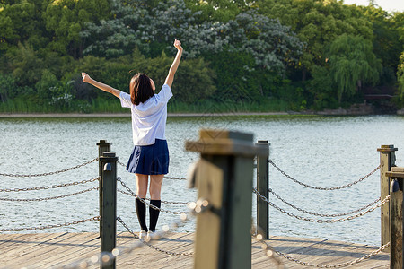 夏天可爱路标牌站在湖边的校服女生背影背景
