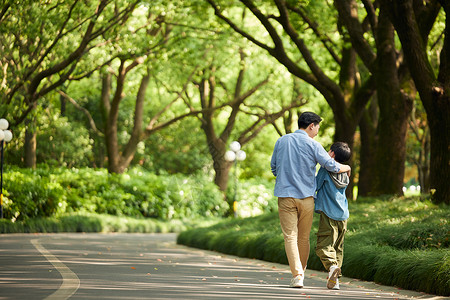 高中生和家长父子在公园散步背影背景