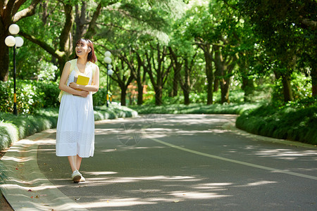 夏天可爱路标牌室外女生抱着书本散步背景