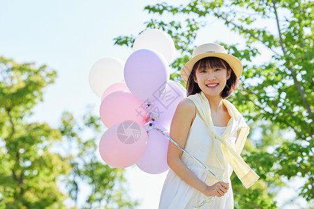 草帽女生公园活力女生手拿气球写真背景