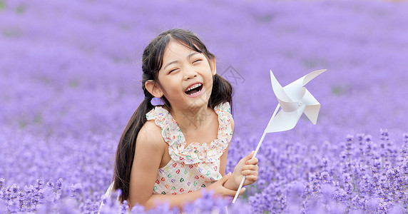 薰衣草花田里手拿风车的女孩高清图片