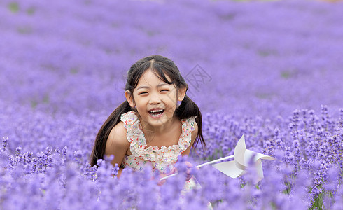 浪漫小清新夏季花朵可爱的小女孩在薰衣草花田大笑背景