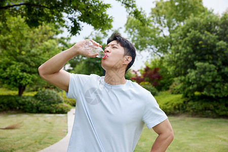夏天户外大口喝水的男性高清图片