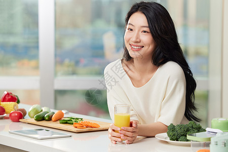 厨房形象女性手捧橙汁在餐桌边形象背景