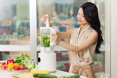白领女性使用榨汁机榨绿色食品高清图片