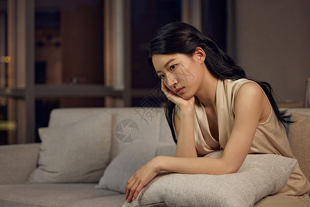 女人趴在沙发靠垫上失落情绪高清图片素材