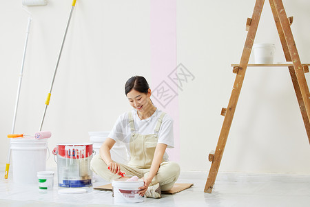 女人盘坐着调试油漆颜色背景图片