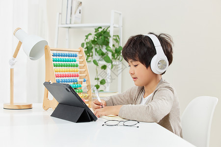 儿童耳机使用平板电脑学习的小男孩背景