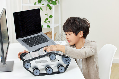 电脑桌前研究组装机器的男孩高清图片