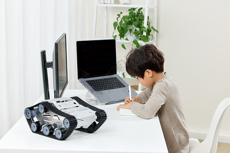 记录笔记男孩在电脑桌前认真记录的男孩背景