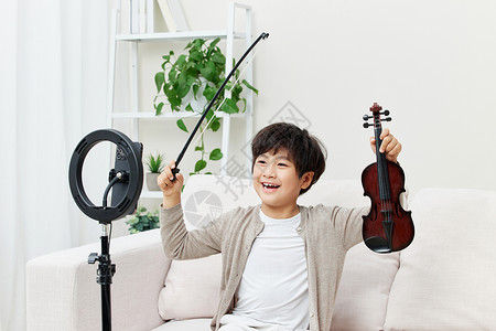 直播拉小提琴的男孩沙发高清图片素材