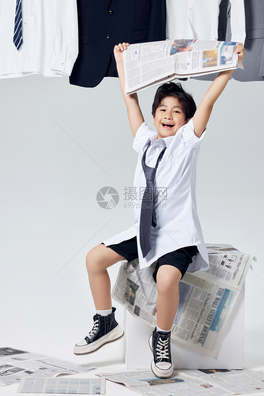 高举报纸欢呼的商务男孩形象图片