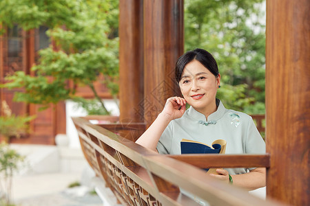 穿着旗袍在古风亭子看书的中年女性图片