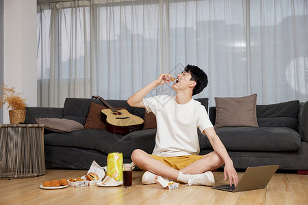 独居男性在沙发前吃吃喝喝形象图片