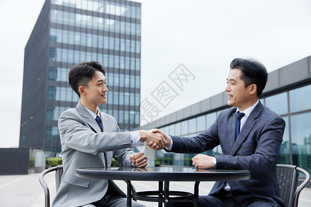 准客户洽谈合作后握手的男人们背景