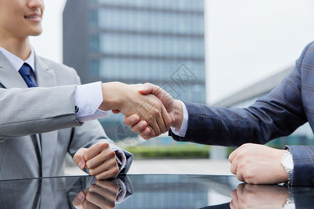 迎接客户男性洽谈合作后握手特写背景