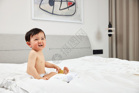 坐在床上开心笑的婴儿宝宝背景图片