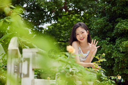 跪着招手的女孩夏季户外女生打招呼背景