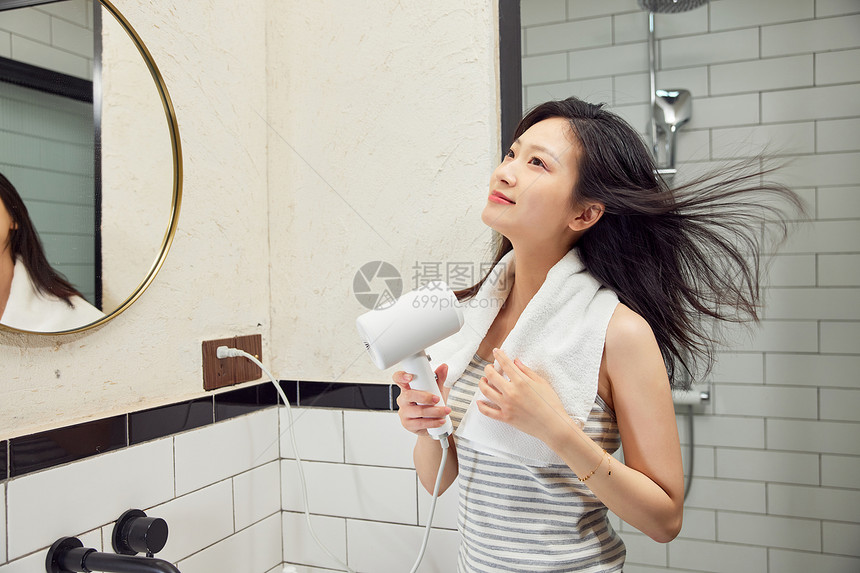 美女浴室使用吹风机吹头发图片