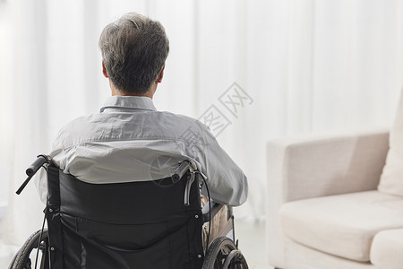 一位空巢老人老人独自坐在轮椅上的背影背景