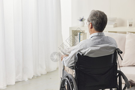 残疾简洁老人独自坐在轮椅上的背影背景