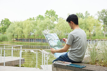 手拿画板户外写生的男性高清图片