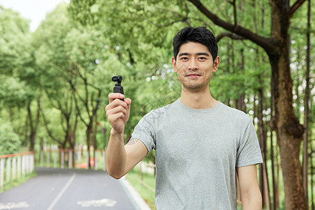 手拿拍摄设备的男性形象背景图片