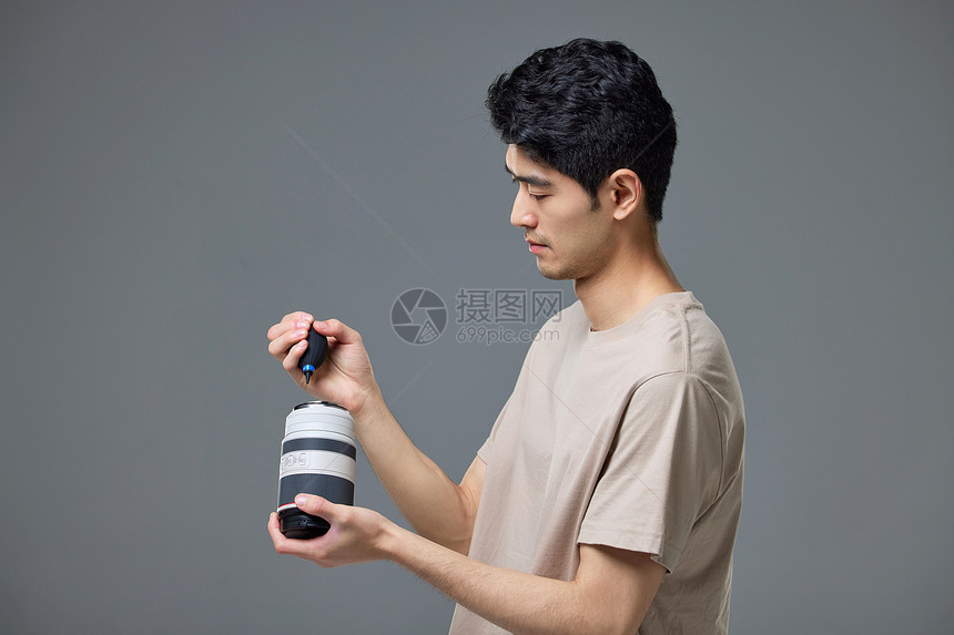 摄影师使用气吹装置清洁镜头图片