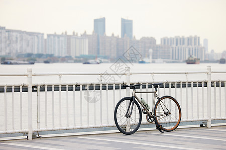 停车栏杆停在江边栏杆上的自行车背景