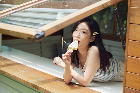 室外纳凉的清纯美女吃冰淇淋背景图片