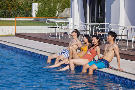 晒太阳的男孩度假酒店泳池边晒太阳的青年们背景